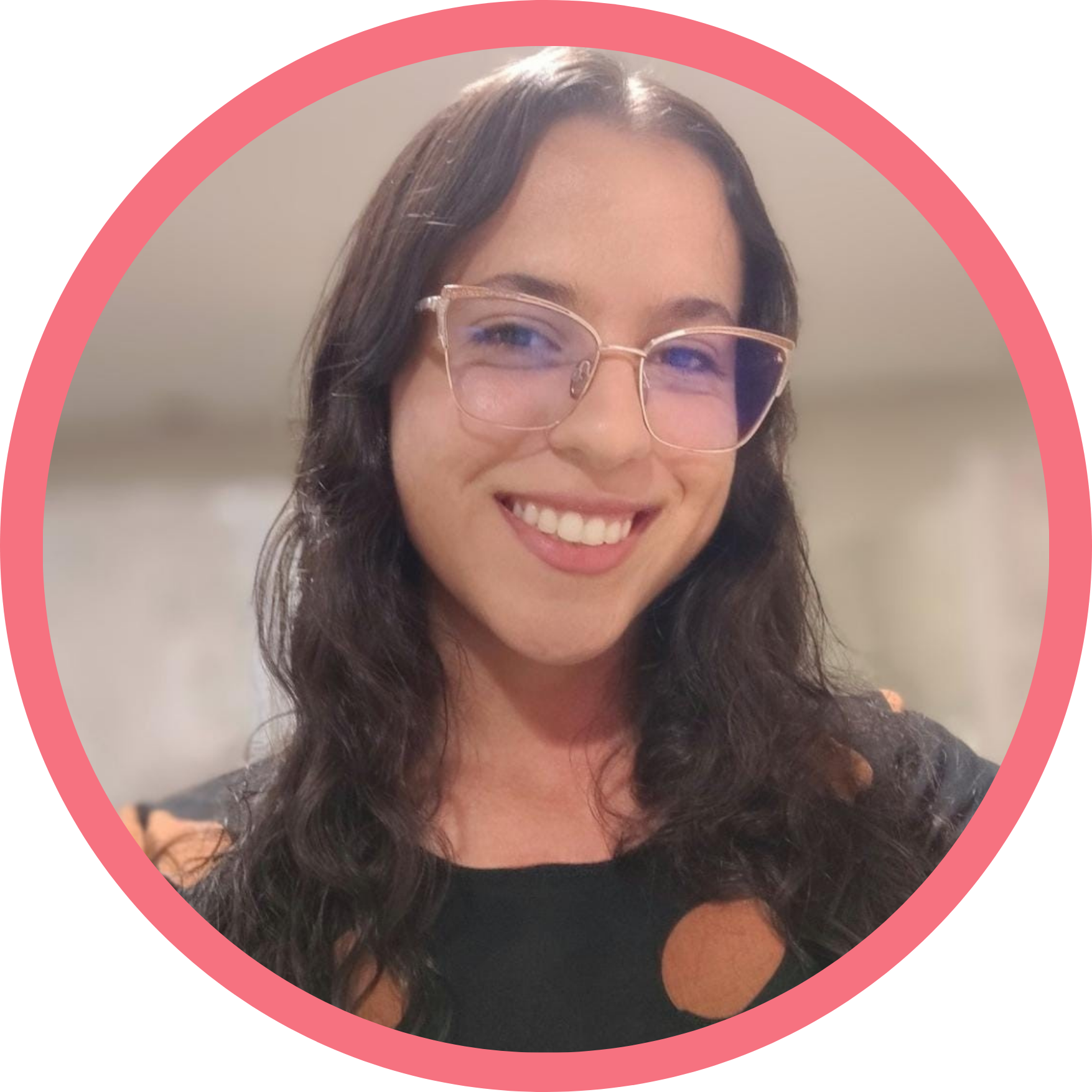 A white woman with long dark brown hair and brown eyes, wearing a transparent-framed glasses and a black dress.